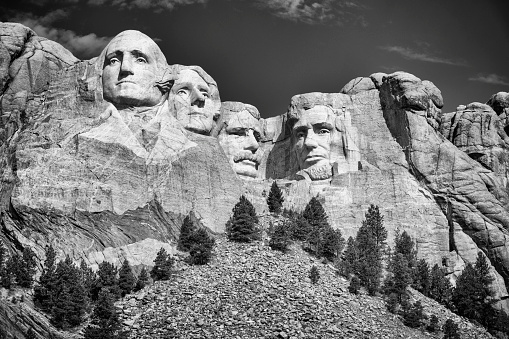 Mount Rushmore National Memorial highlighted by the sculpture of four American presidents carved into the mountainside located in the Black Hills of Pennington County, South Dakota.