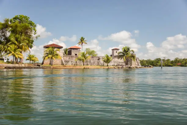 Photo of Scenic landscape with Spanish colonial fortress called Castillo de San Felipe de Lara on the water of the Rio Dulce