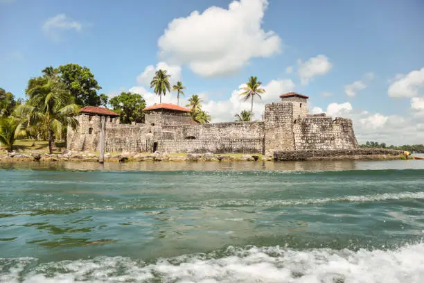 Scenic landscape with Spanish colonial fortress called Castillo de San Felipe de Lara on the water of the Rio Dulce, Guatemala