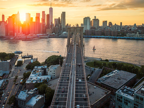 Aerial of a sunset at Brooklyn bridge overlooking downtown Manhattan on a warm summer day