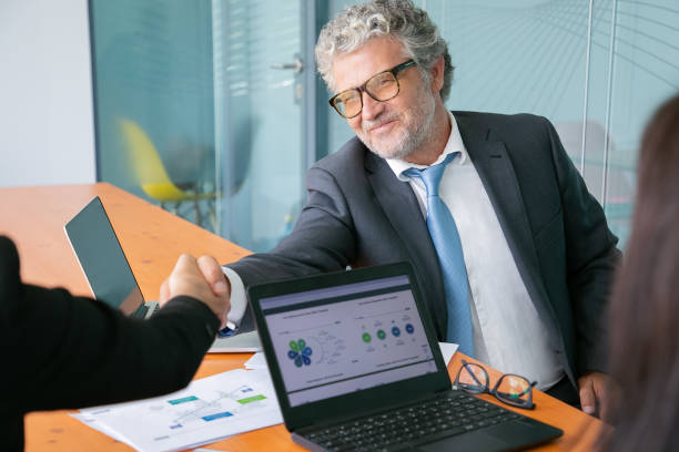 istock Grey-haired Caucasian businessman handshaking and smiling 1270356545