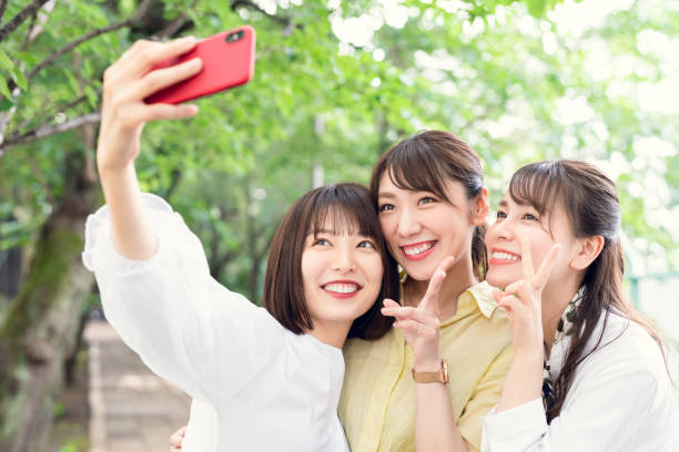 自分撮りを取るアジアの女性のグループ。 - 観光客 写真 ストックフォトと画像