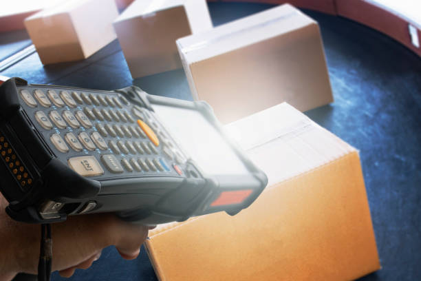 istock Worker scanning barcode scanner with shipment boxes on conveyor belt. Manufacturing warehouse export. Computer equipment for inventory management. 1270361096