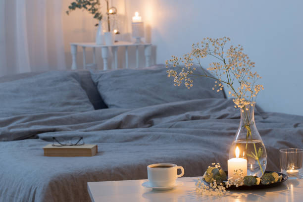 intérieur de nuit de la chambre à coucher avec des fleurs et des bougies brûlantes - in the evening photos et images de collection