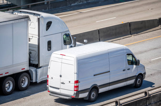 big rig semi truck mit trockenwagen-sattelanhänger und kompakt-kleintransporter fährt nebeneinander auf der mehrzeiligen autobahnstraße - van white truck mini van stock-fotos und bilder