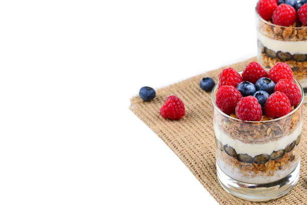 istock Healthy blueberry and raspberry parfait in a glass on a rustic white wood background. Two portions. Space for text or design. 1270364363