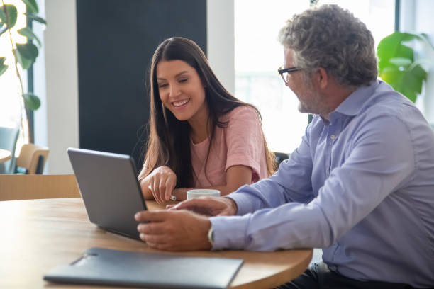istock Mature professional showing content on laptop 1270366413