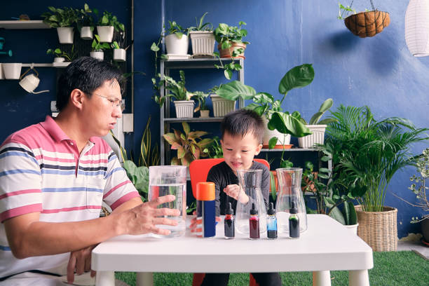 istock Parent sitting homeschooling with little kid, Father and son having fun preparing easy science experiment, Kid-friendly easy science experiments at home concept 1270367462