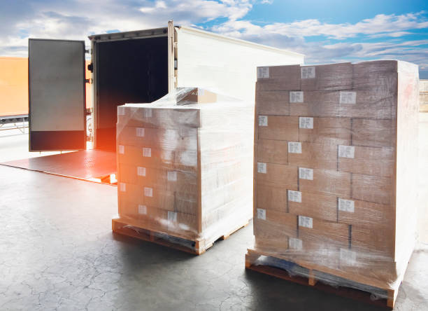 istock Logistics and transportation. Cargo freight, Shipment, Delivery service. Warehouse docks. Stacked package boxes on pallet waiting to load into cargo container truck. 1270368748