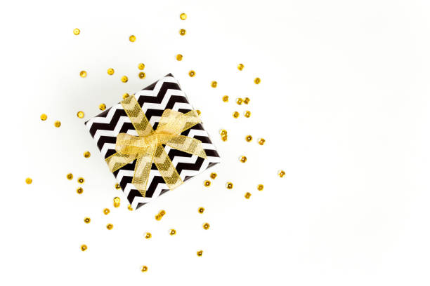 Gift or present box and stars confetti on a white background. Colorful celebration, birthday. Christmas or New Year pattern. Flat lay, top view