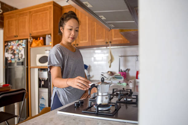 asian woman making an espresso with italian coffee pot - buns of steel imagens e fotografias de stock