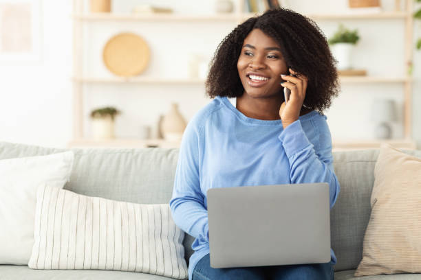 istock Happy girl using laptop, talking on phone 1270373176