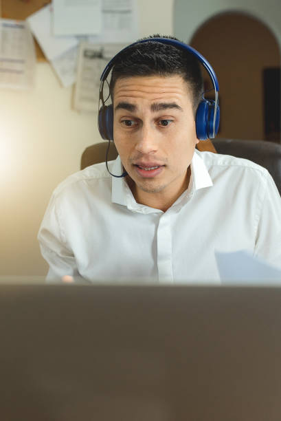 istock Man using laptop with headphones having a video call. Working at home concept. 1270373483
