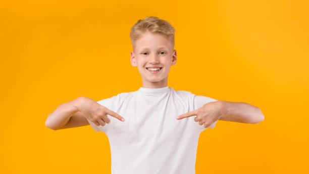 menino feliz apontando dedos para si mesmo - t shirt child white portrait - fotografias e filmes do acervo