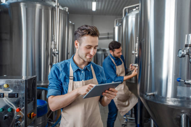 istock Quality control on brewery. Guys work near brewing kettles using tablet 1270375714