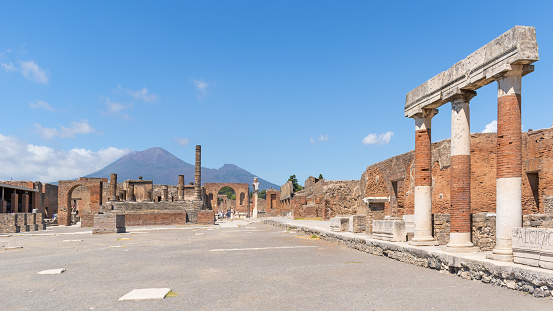 Temple columns and gate with Vesuvius volcano in the background at the ancient Roman city of Pompeii, Italy