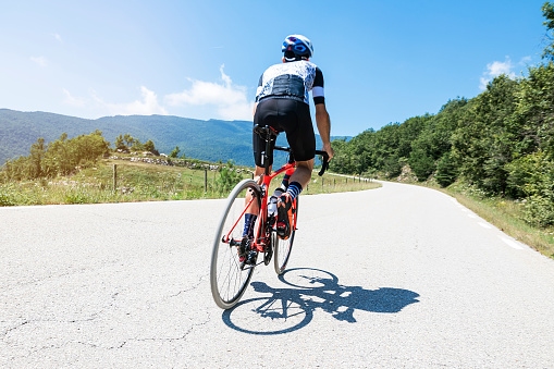 back view of a cyclist on top of a mountains. sport concept