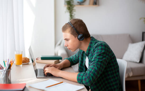 istock Concentrated nerd boy having online lesson, studying from home 1270377555
