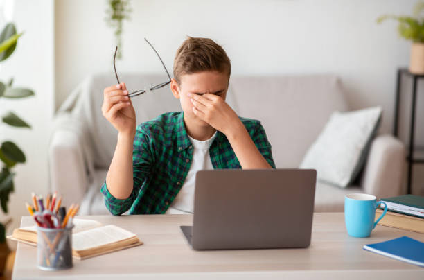 istock Tired schooler rubbing his eyes, holding glasses 1270377585