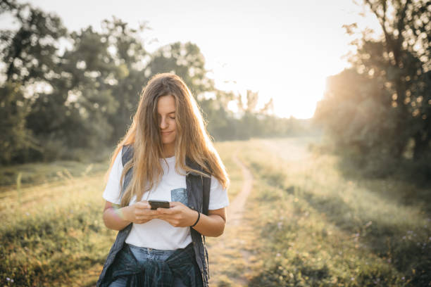 istock A young woman uses her phone while walking in the morning 1270378208
