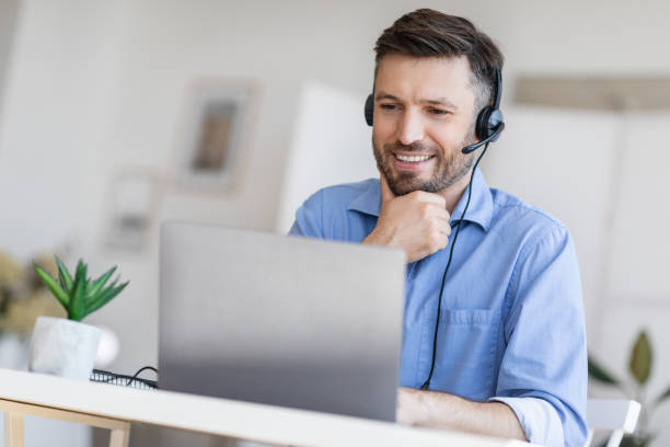 istock Hotline Support Service. Male call center operator in headset working with laptop 1270378813