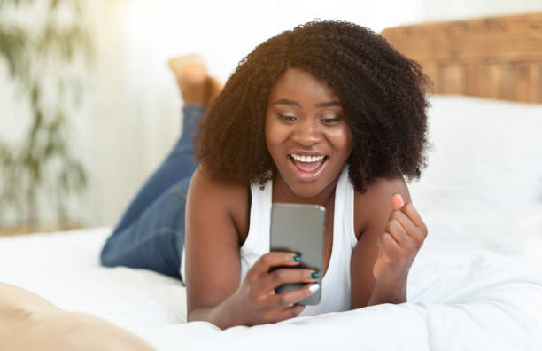 istock Excited afro girl feeling ecstatic holding phone 1270379621
