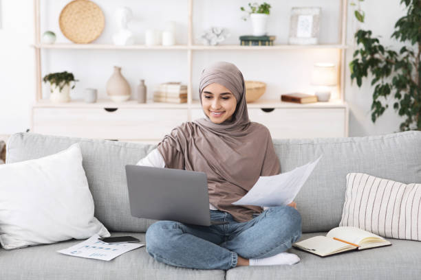 istock Home Office. Busy Arabic Woman Working With Laptop And Documents On Couch 1270381831