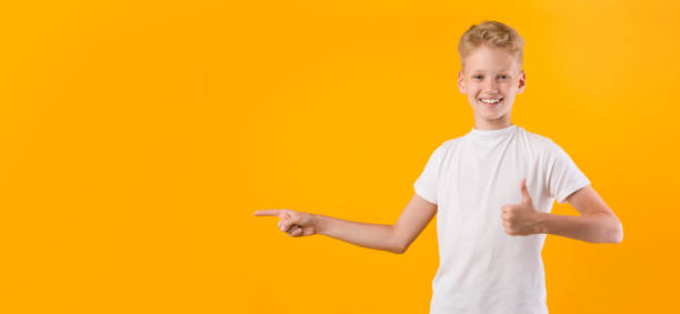 istock Happy boy pointing fingers aside at copy space 1270382077