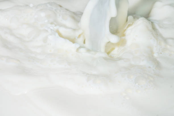 istock Drops of liquid milk pouring down or white drops with ripples 1270382329