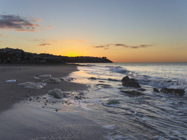 istock Sunrise at the beach with waves and rocks 1270382425