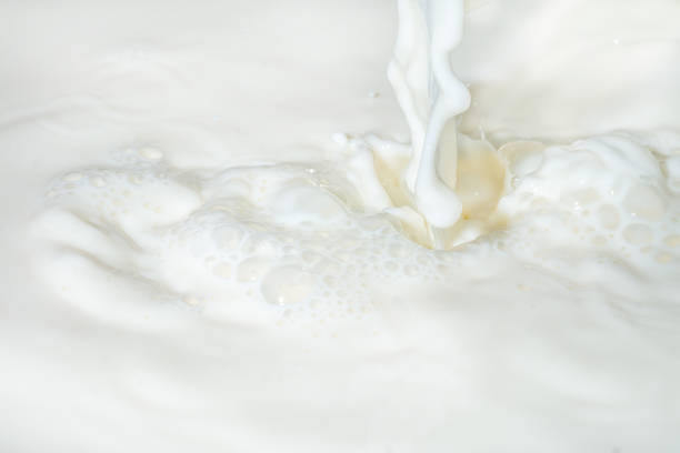 istock Drops of liquid milk pouring down or white drops with ripples 1270382459
