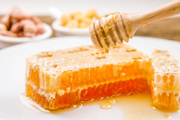 istock Honey with sweet honeycomb and dipper on a white plate 1270382468