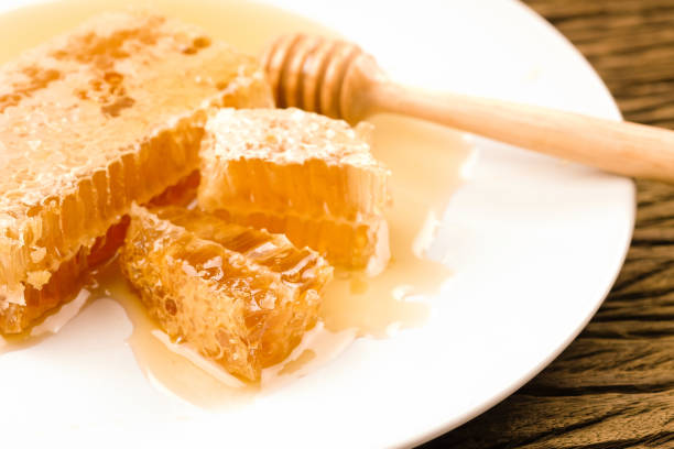istock Honey with sweet honeycomb and dipper on a white plate 1270382472