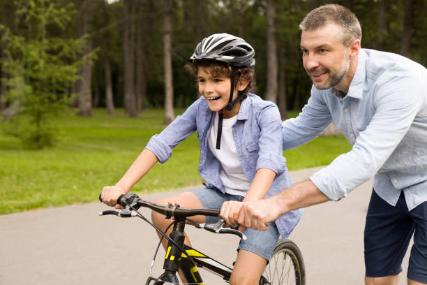 istock Boy learning to ride a bicycle with his father 1270383120