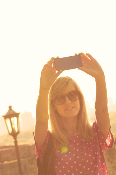istock Young woman using modern smartphone in urban surroundings. 1270383897