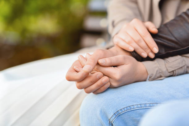 istock Woman holding man hand with both hands, sitting on bench 1270384688
