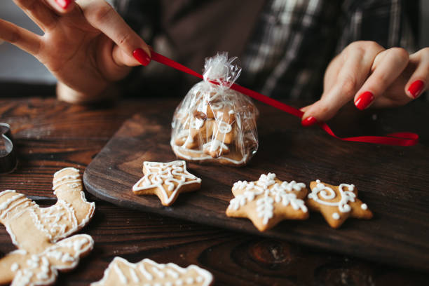 크리스마스 진저 브레드 쿠키를 포장하��는 여성 - bakery biscuit christmas decoration christmas ornament 뉴스 사진 이미지