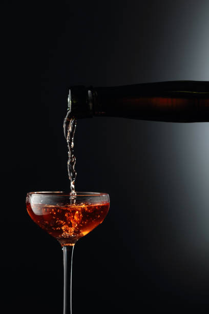 silny złoty napój alkoholowy z antycznej butelki wlewa się do szklanki. - grappa photography food and drink vertical zdjęcia i obrazy z banku zdjęć