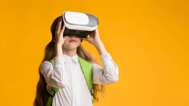 istock Little Schoolgirl Experiencing Virtual Reality On Yellow Studio Background, Panorama 1270386961