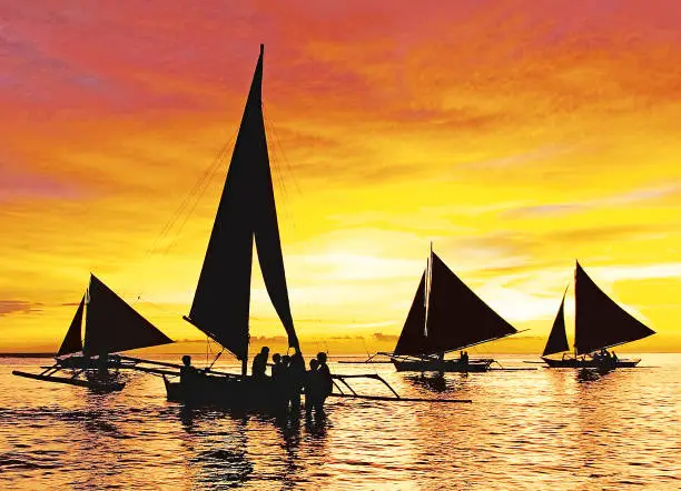 Photo of Silhouette sailing boats at sunset on Boracay