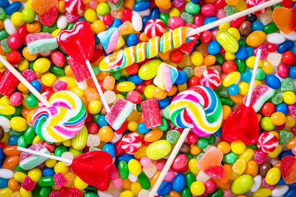 Top view of an assortment of multicolored candies, lollipops and jelly beans background. Studio shot taken with Canon EOS 6D Mark II and Canon EF 24-105 mm f/4L