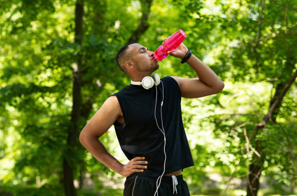 istock Thirsty young athlete drinking water from bottle after his training at park 1270389643
