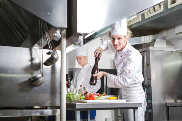 Smiling female chef decorating vegetable dish.
