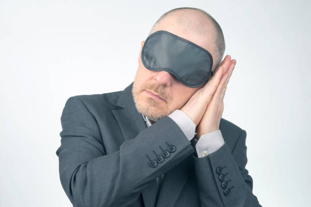 istock business man in blindfold for sleeping with arms raised for rest on a white background 1270394117