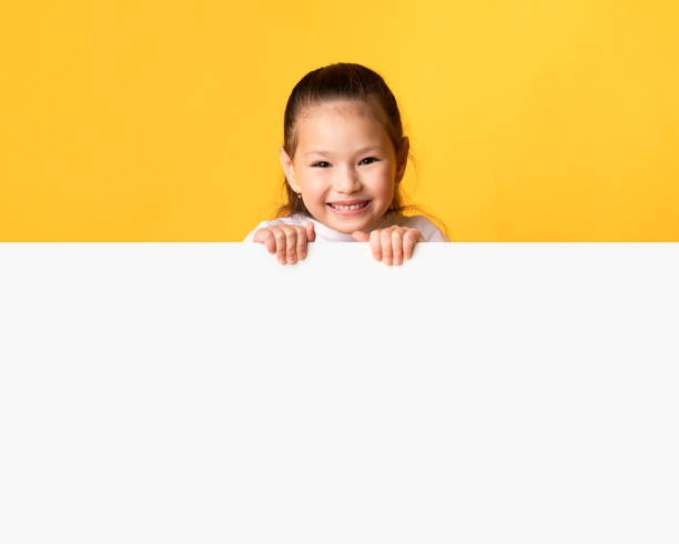 istock Asian girl hiding behind blank white advertising billboard 1270394862