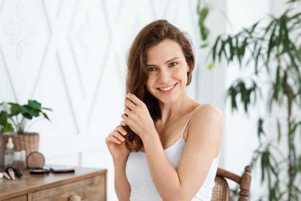 Happy young woman touching her silky hair Hair care concept. Happy young woman touching her silky hair, home interior, copy space Combing stock pictures, royalty-free photos & images