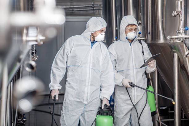 istock Quality control equipment. Men in protective suits and masks look at tablet 1270395250