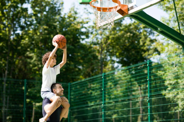 istock Happy father helps his son to score a basket 1270395322