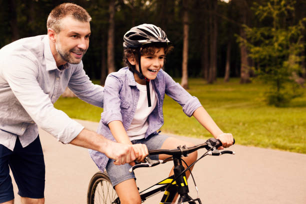 istock Boy learning to ride bicycle with his dad 1270395911