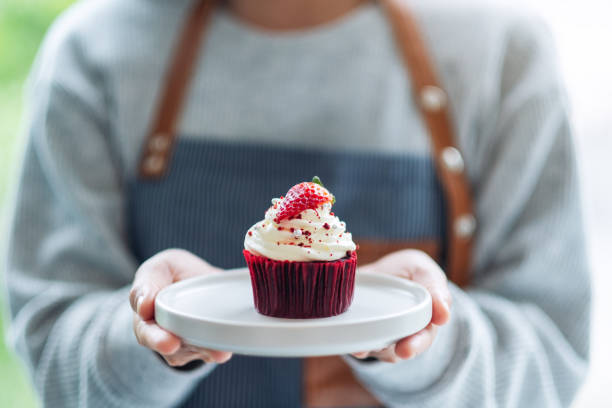 istock A waitress holding and serving a red velvet cupcake 1270395970